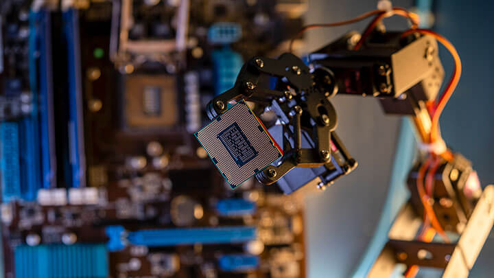 Industriel robotarm, der holder en CPU-chip