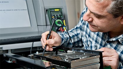 En mand holder et multimeter i et elektrisk produkt.